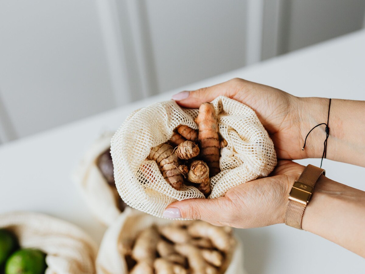 Fresh turmeric roots in a mesh bag