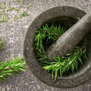Fresh rosemary sprigs in a stone mortar and pestle